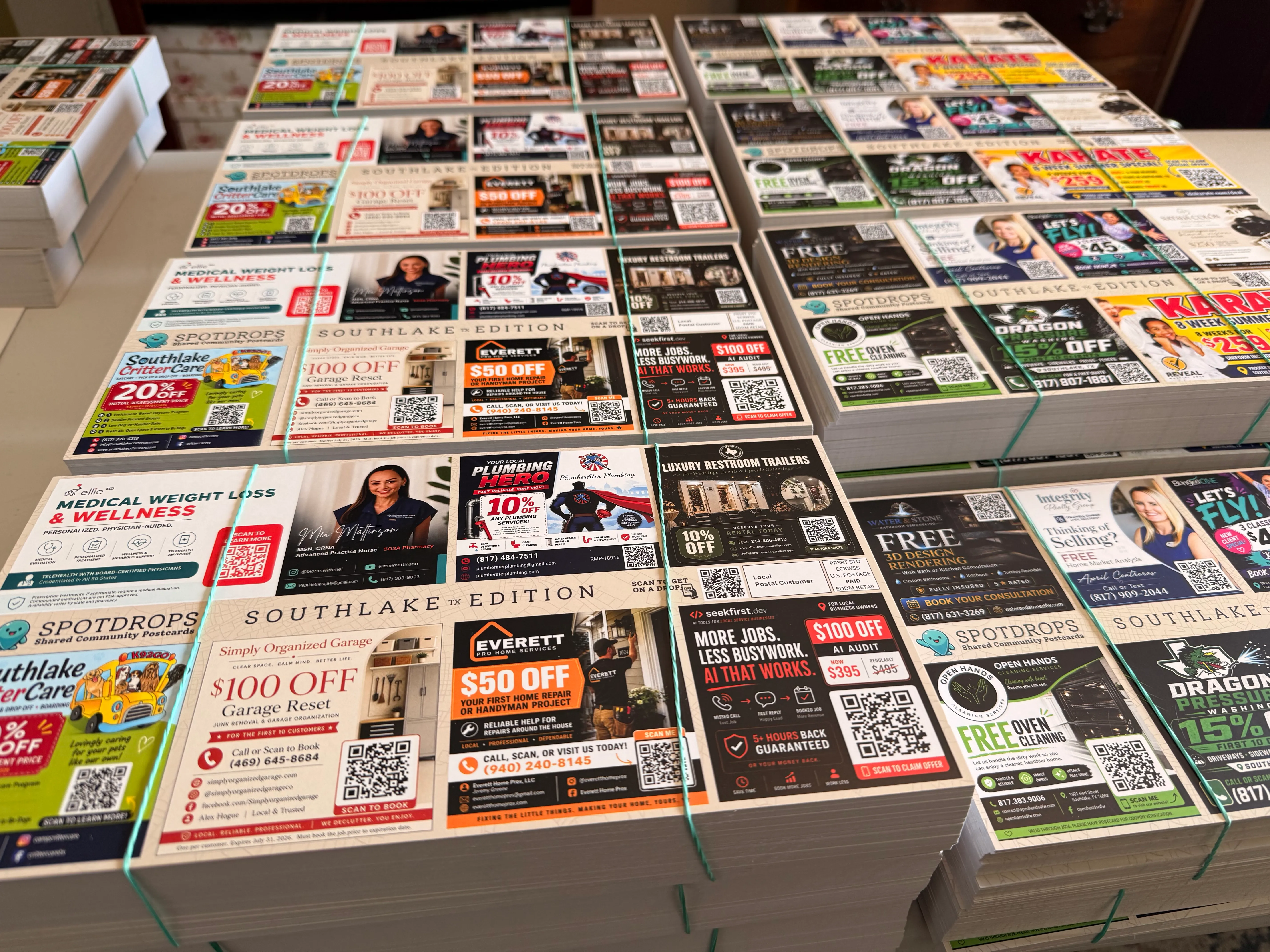 Dustin’s printed SpotDrops Southlake community postcards, stacked and bundled for mailing.